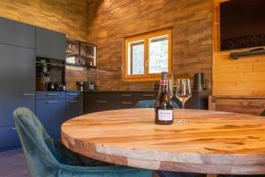 a bottle of wine on a wooden table in a kitchen at Ferienwohnung Aegimatte in Ulrichen