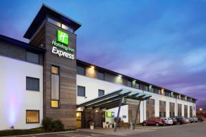 a hotel with a sign on the side of a building at Holiday Inn Express Cambridge by IHG in Cambridge