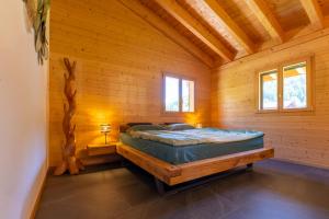 a bedroom with a bed in a wooden cabin at Ferienwohnung Aegimatte in Ulrichen +17 photos