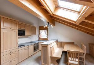 a kitchen with wooden cabinets and a table and a window at Residenz Château Leukerbad in Leukerbad +5 photos