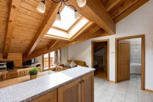a kitchen with a vaulted ceiling with a skylight at Residenz Château Leukerbad in Leukerbad