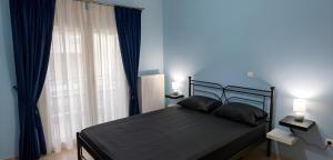 a bedroom with a bed with blue walls and a window at Relaxing home 80m from the sea in Perea