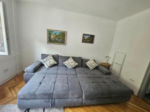 a couch in a living room with a gray couch at Sweet Escape Pécs in Pécs