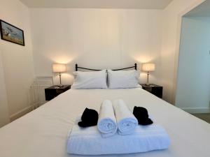 a bedroom with a white bed with towels on it at Glenrigh House - The Garden Flat in Fort William
