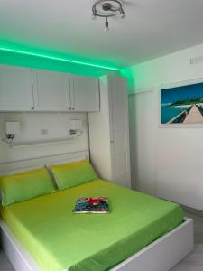 a bedroom with a green bed with white cabinets at SoleMare Rooms "Smeraldo" in Procida