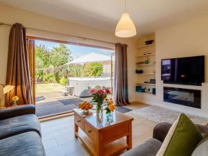 a living room with a couch and a table with flowers on it at 3 Bed in Kings Lynn oc-43259 in Dersingham