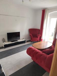 ein Wohnzimmer mit einem roten Sofa und einem Tisch in der Unterkunft imperial 1 in Leuenberg