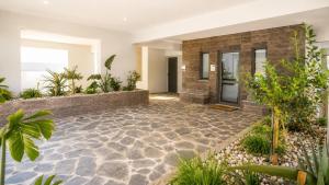 an indoor courtyard with a stone floor and plants at Athinais Karystos in Karistos
