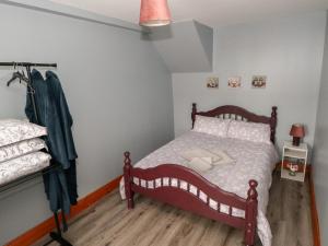a bedroom with a bed with a wooden floor at Tí Maolla in Hollymount