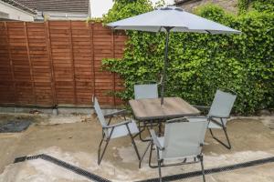 a table and chairs with an umbrella in a backyard at Tí Maolla in Hollymount