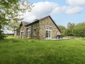 ein Steinhaus mit einem Picknicktisch davor in der Unterkunft Ty Cellin in Ystrad Meurig