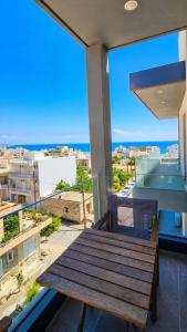a wooden table on a balcony with a view of the ocean at Athinais Karystos in Karistos