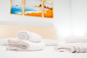 a pile of towels sitting on top of a bed at Gridia Apartment in Chios +42 photos