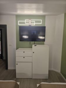 a living room with a tv and a white dresser at Villa George in Constanţa +29 photos