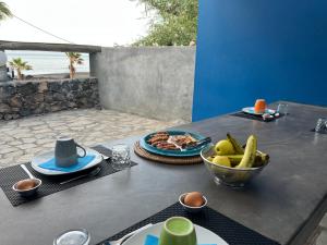 a table with a plate of food and a bowl of bananas at Cap-Azul in Porto Novo