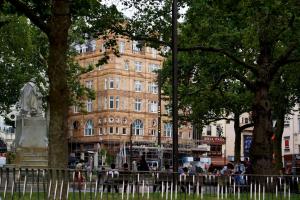 a large building with a statue in front of it at Victory House Leicester Square in London