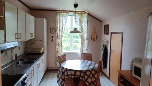 a kitchen with a table and a sink and a window at Förvaltarbostaden in Åtvidaberg