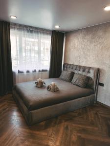 two stuffed animals sitting on a bed in a bedroom at Skersgatvio Apartmentai in Zarasai
