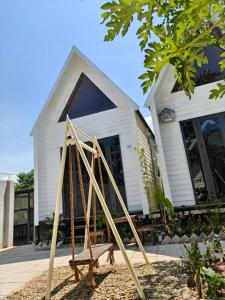 a house with a wooden frame in front of it at GiGi's Homestay & Coffee in Phú Xá