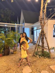 two women and two children standing in front of a house at GiGi's Homestay & Coffee in Phú Xá +7 photos