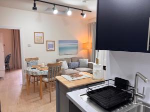 eine Küche und ein Wohnzimmer mit Sofa und Tisch in der Unterkunft Glenrigh House - Loch View Flat for 2 in Onich