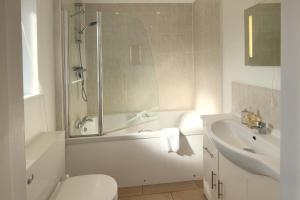 a bathroom with a toilet and a tub and a sink at Cottages by the Moat in Hassocks +18 photos