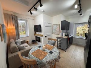 ein Wohnzimmer mit einem Tisch und einem Sofa in der Unterkunft Glenrigh House - Loch View Flat for 2 in Onich
