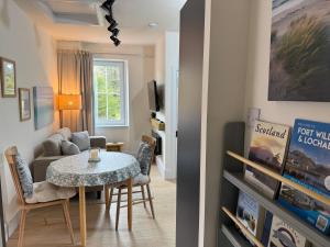 ein Wohnzimmer mit einem Tisch und einem Sofa in der Unterkunft Glenrigh House - Loch View Flat for 2 in Onich