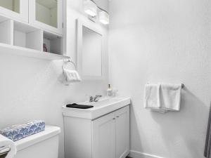 a white bathroom with a sink and a mirror at Mountain Edge 1020 our Holiday Home in Kimberley +85 photos
