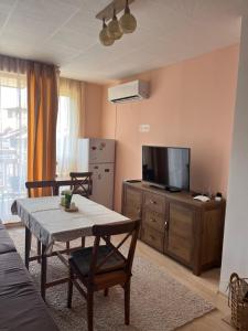 a living room with a table and a television at Mirabell Apartment Bansko - Mountain View & Fireplace in Bansko