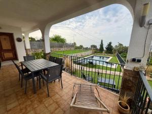 a balcony with a table and chairs and a pool at Villa Mar in Teià