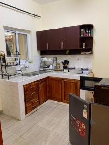 a kitchen with wooden cabinets and a sink and a refrigerator at Iconic lux living in Malindi