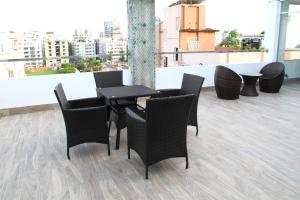 a table and chairs on the roof of a building at Blossom Hotel Dhaka in Dhaka