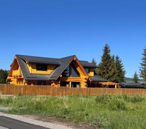 a log home with a black roof at Chalet Marilyn in Topliţa