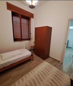 a bedroom with a bed and a cabinet and a rug at La casa rossa in Siderno Marina +6 photos
