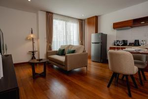 a living room with a couch and a kitchen at The Scenic Hotel in Phnom Penh