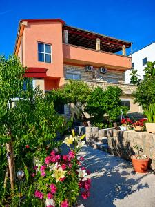 a house with flowers in front of it at Apartmani Tomić in Seline
