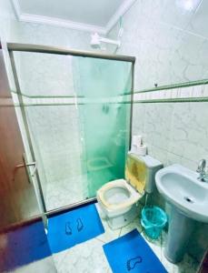a bathroom with a shower and a toilet and a sink at Nossa Casa Arraial LOFT in Arraial do Cabo