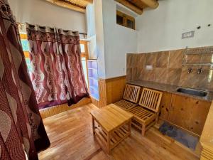 a living room with a bench and a window at Sponbo Guest House, Leh in Leh