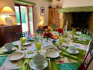 a dining room table with plates and glasses on it at Le Manoir du Rocher in Domme