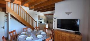 a dining room with a table and a flat screen tv at duplex appartement 6 à 8 personnes in Guchan