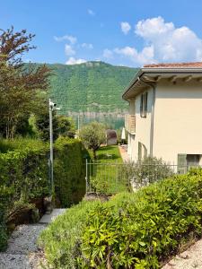a house with a fence and a mountain in the background at Verdolivo in Sale Marasino +47 photos