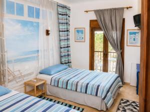 a bedroom with two beds and a window with the ocean at Oliver Santiago Mallorca in Cala Figuera +12 photos