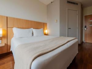 a large white bed in a hotel room at Ibis Florianopolis in Florianópolis