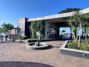 a statue in front of a building with palm trees at Ocean Sunrise! in Ballito