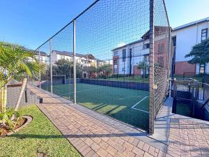 a tennis court in front of a building at Ocean Sunrise! in Ballito