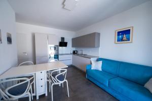 a living room with a blue couch and a kitchen at Casa Vacanze Costa del Sole in Riva di Solto