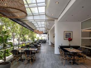 a restaurant with tables and chairs and a glass ceiling at Novotel Santiago Vitacura in Santiago
