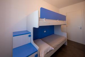 a small room with a bunk bed with blue shelves at Casa Vacanze Costa del Sole in Riva di Solto