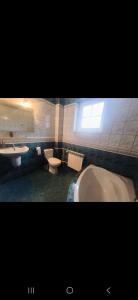a bathroom with two toilets and a tub and a sink at Dom Na Fali in Pasym